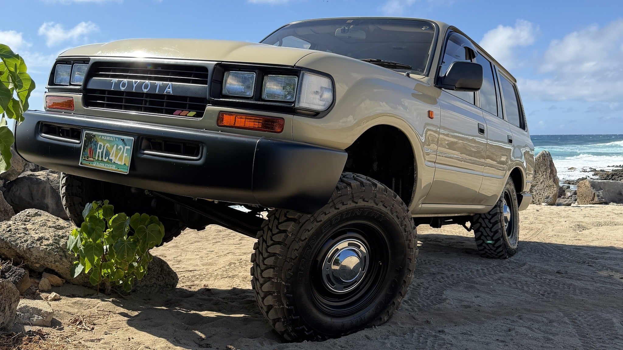 80-Series Land Cruiser on lava rocks, wide